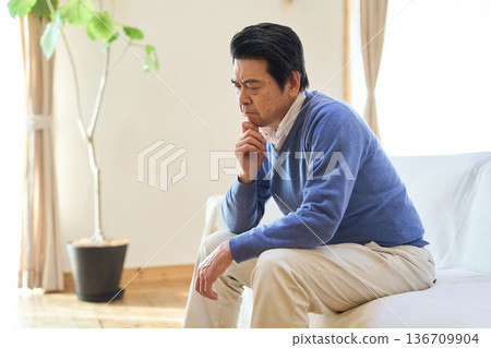 一位憂心忡忡的亞洲老者獨自待在房間裡 136709904