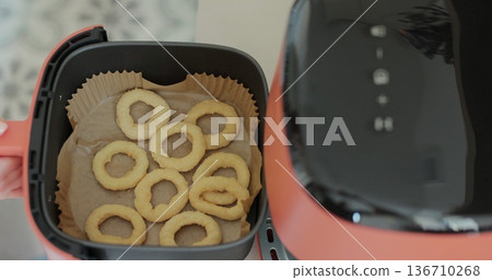 Cooking onion rings in the air fryer. Healthy food for diet eating. Cooking onion rings in the air fryer. Healthy food for diet eating. 136710268