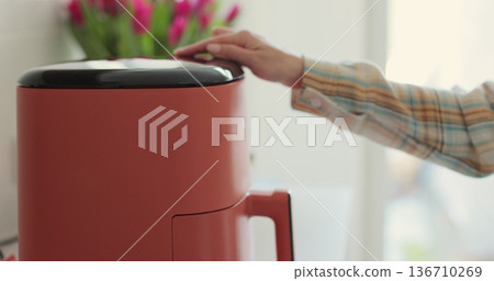 Close-up of air fryer in kitchen - concept of preparing a healthy dessert. Smart device at home kitchen. Close-up of air fryer in kitchen - concept of preparing a healthy dessert. Smart device at home kitchen. 136710269
