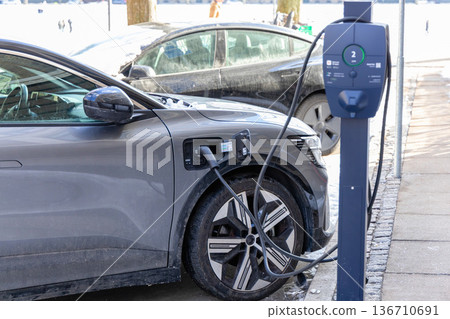 Electric car charging at public station in winter Electric car charging at public station in winter 136710691