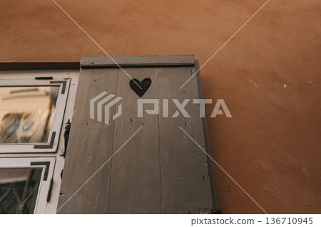 Wooden box with heart shape cutout on brown wall showing simple design in urban area 136710945
