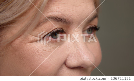 Close up mature woman eye area skin texture. Close up mature woman eye area skin texture. 136711131