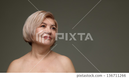 Mature woman looking up natural beauty studio portrait. 136711266