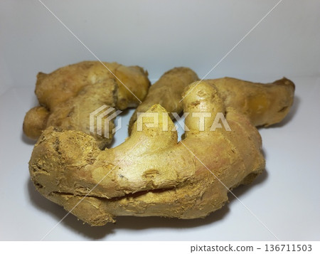 Fresh ginger root resting on a clean white surface. 136711503