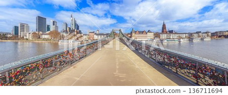 Iron footbridge with Frankfurt skyline over river Main Iron footbridge with Frankfurt skyline over river Main 136711694