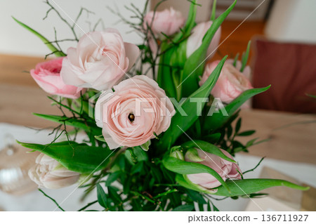 Detailed floral bouquet featuring ranunculus and roses. Soft focus and natural tones emphasize texture and seasonal freshness. 136711927