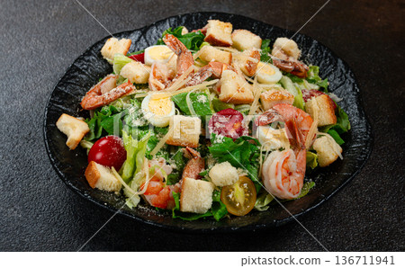 caesar salad with tiger prawns, shrimp salad, lettuce leaves, quail eggs, cherry tomatoes, parmesan cheese, on a black plate, caesar salad with tiger prawns, shrimp salad, lettuce leaves, quail eggs, cherry tomatoes, parmesan cheese, on a black plate, 136711941