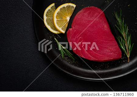 fresh red tuna fillet, for steak, raw, top view, on a black plate , no people, fresh red tuna fillet, for steak, raw, top view, on a black plate , no people, 136711960