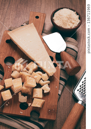 Freshly sliced and grated cheese, parmesan cheese, on a wooden chopping board, rustic style, no people Freshly sliced and grated cheese, parmesan cheese, on a wooden chopping board, rustic style, no people 136711969