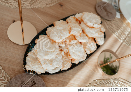 Airy meringue sweets as part of festive table setting. Soft light and natural textures make it ideal for wedding dessert tables and celebration styling concepts. Airy meringue sweets as part of festive table setting. Soft light and natural textures make it ideal for wedding dessert tables and celebration styling concepts. 136711975