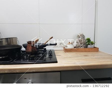 A stove with a pot and dishes A stove with a pot and dishes 136712292