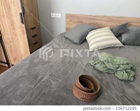 A bed with a wooden clothes and pillows A bed with a wooden clothes and pillows 136712293