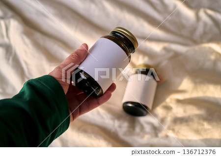Hand holding supplement bottle with blank label Hand holding supplement bottle with blank label 136712376