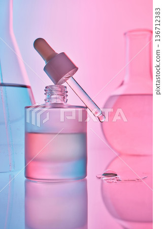 Skincare serum dropper with laboratory flasks in pink and blue light Skincare serum dropper with laboratory flasks in pink and blue light 136712383