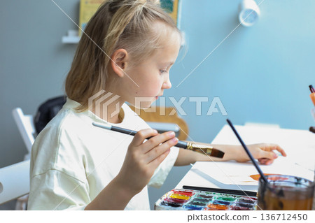 Beautiful young child painting at home. Close-up portrait of little girl indoor Beautiful young child painting at home. Close-up portrait of little girl indoor 136712450