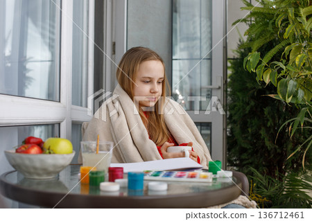 Pretty girl holding drink and sitting on terrace, portrait. Child drinking Pretty girl holding drink and sitting on terrace, portrait. Child drinking 136712461