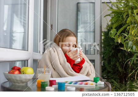 Attractive girl holding drink and sitting on terrace, portrait. Child drinking 136712505