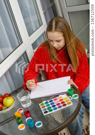 Adorable child drawing pink cats in a sketchbook. Young preteen girl painting Adorable child drawing pink cats in a sketchbook. Young preteen girl painting 136712509