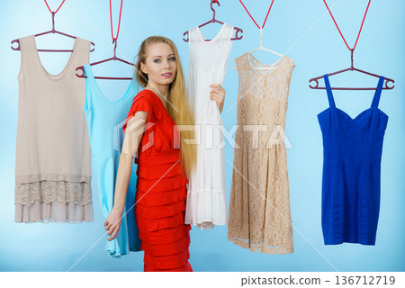 Woman choosing clothes in shop Woman choosing clothes in shop 136712719