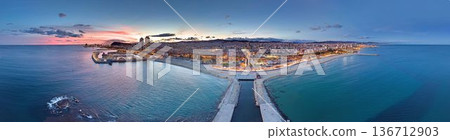 Barcelona city lights panorama at sunset over Mediterranean sea 136712903