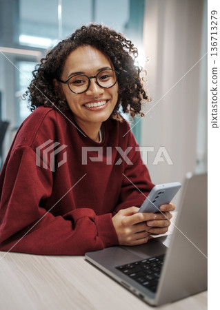 Pleasant Woman Engaging With Modern Ecommerce Platform On Her Mobile Device With Satisfaction Pleasant Woman Engaging With Modern Ecommerce Platform On Her Mobile Device With Satisfaction 136713279