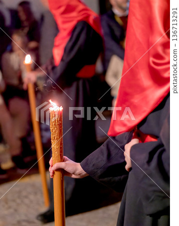 Detailed view of a hand holding a large lit candle in a religious procession Detailed view of a hand holding a large lit candle in a religious procession 136713291