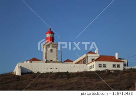 Red lighthouse tower and traditional white buildings at Cabo da Roca, Portugal. Red lighthouse tower and traditional white buildings at Cabo da Roca, Portugal. 136713488