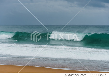 Waves crashing on the sandy beach in Labenne, Landes, France, on a cloudy day. Waves crashing on the sandy beach in Labenne, Landes, France, on a cloudy day. 136713514
