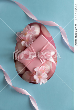 Easter Gift Box with Decorated Eggs and Blossoms in Heart Cutout. Festive Spring Flatlay on Blue Background Easter Gift Box with Decorated Eggs and Blossoms in Heart Cutout. Festive Spring Flatlay on Blue Background 136713583