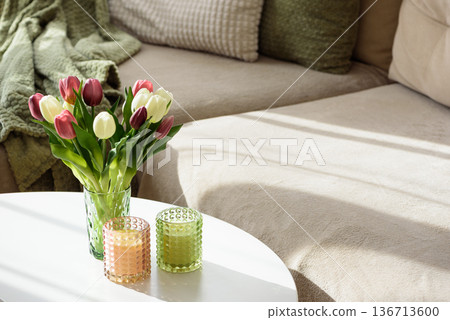Living Room Decorated Spring Tulip Bouquet in Green Vase and Candles. Cozy Home Decor Arrangement Living Room Decorated Spring Tulip Bouquet in Green Vase and Candles. Cozy Home Decor Arrangement 136713600