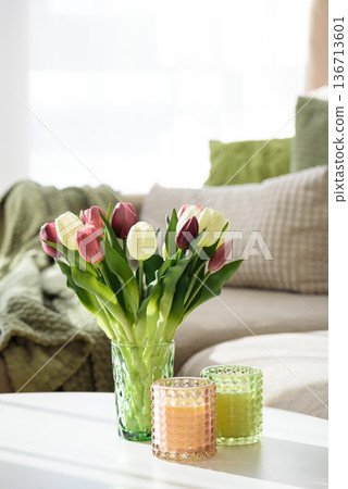 Living Room Decorated Spring Tulip Bouquet in Green Vase and Candles. Cozy Home Decor Arrangement Living Room Decorated Spring Tulip Bouquet in Green Vase and Candles. Cozy Home Decor Arrangement 136713601