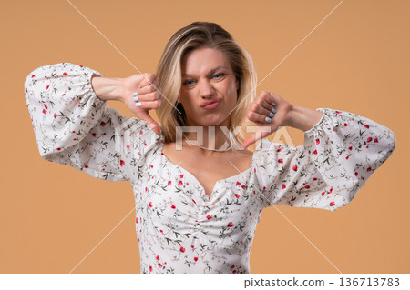 Blonde Woman With Sign Of Dislike. Grimacing Pretty Lady Showing Thumbs-Down Blonde Woman With Sign Of Dislike. Grimacing Pretty Lady Showing Thumbs-Down 136713783
