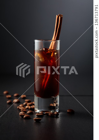 Coffee liquor with ice in tall glass on a black background. Coffee liquor with ice in tall glass on a black background. 136713791