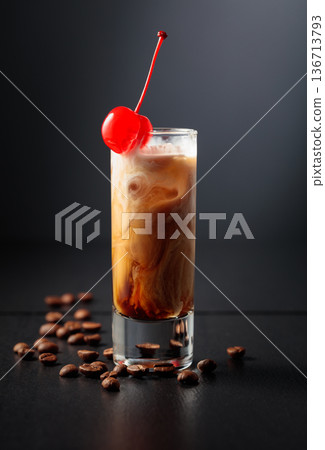 Cream and coffee liquor with ice in tall glass on a black background. 136713793