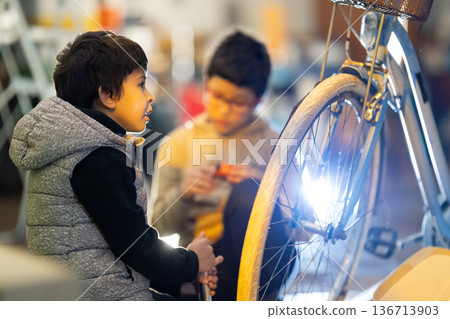 Students learning bicycle repair skills workshop 136713903