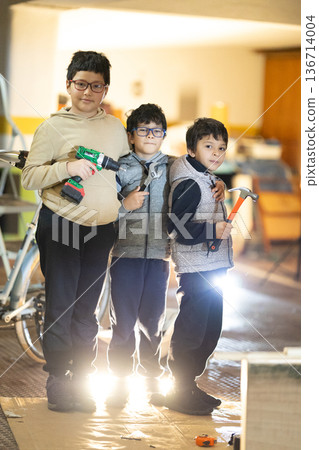 Three boys playing with tools learning handiwork skills 136714004