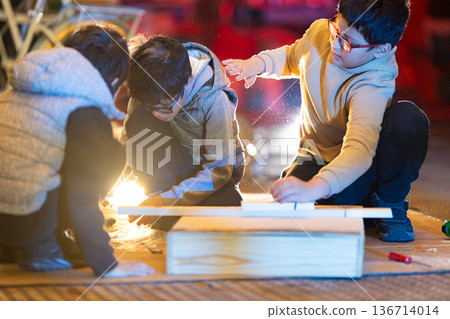 Children learning woodworking together in a creative workshop 136714014