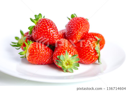 Ripe strawberries on a white plate, isolated on a white background Ripe strawberries on a white plate, isolated on a white background 136714604