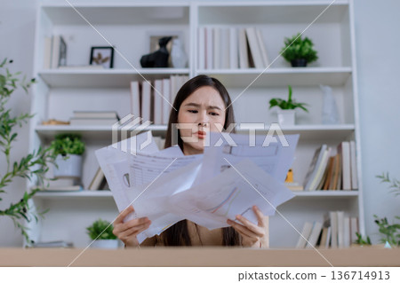 Businesswoman angry throwing papers over the herself in office Businesswoman angry throwing papers over the herself in office 136714913