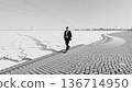 Man Walking Along Frozen Expanse 136714950