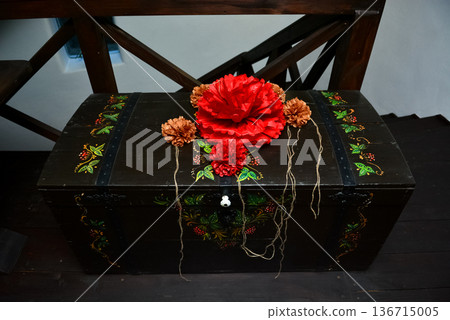 Traditional wooden chest decorated with red paper flowers Traditional wooden chest decorated with red paper flowers 136715005