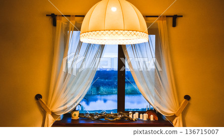 Cozy window view at twilight with a large lampshade Cozy window view at twilight with a large lampshade 136715007