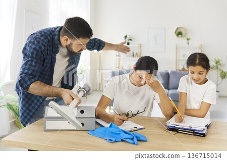 Overloaded mother with paperwork as father demands cleaning, child studies at home Overloaded mother with paperwork as father demands cleaning, child studies at home 136715014