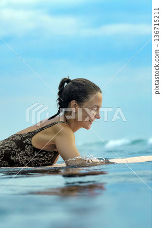 Smiling Young Lady Engaged In Peaceful Paddle As Sunrise Gently Lights Water 136715211