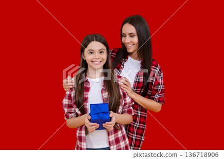 Mother and daughter. Gift for Mothers Day. Gift for mother. Birthday or Valentines Day for Mother. Womens Day. Surprise Mother with gift. Holiday with mom, child. Celebrate family happiness. 136718906