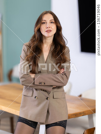 Woman standing in jacket without bra in front of office background 136719046