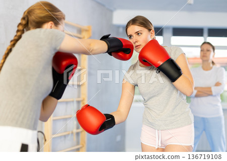 Teen girls in punch mitts boxing 136719108