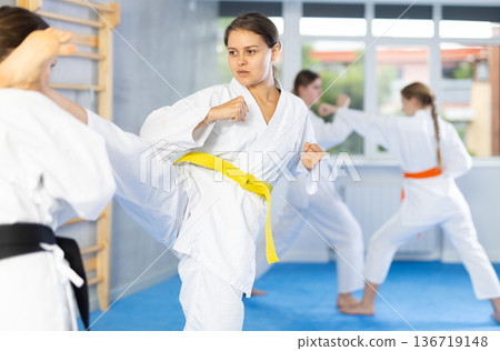 Females in kimono practicing fighting moves 136719148