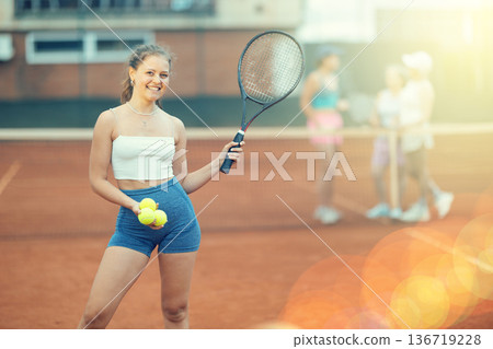 Young woman posing on tennis court 136719228