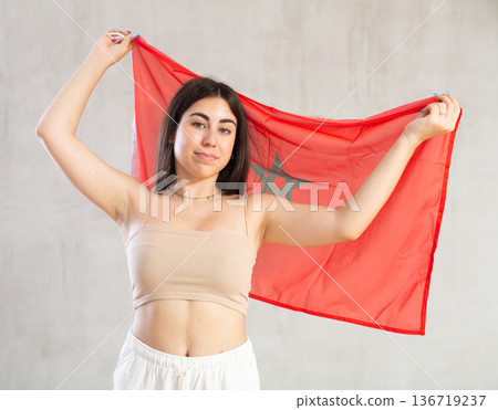 Happy young woman with flag of Monaco against unicoloured background 136719237